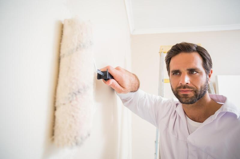 professional painter working at wall rolling 
